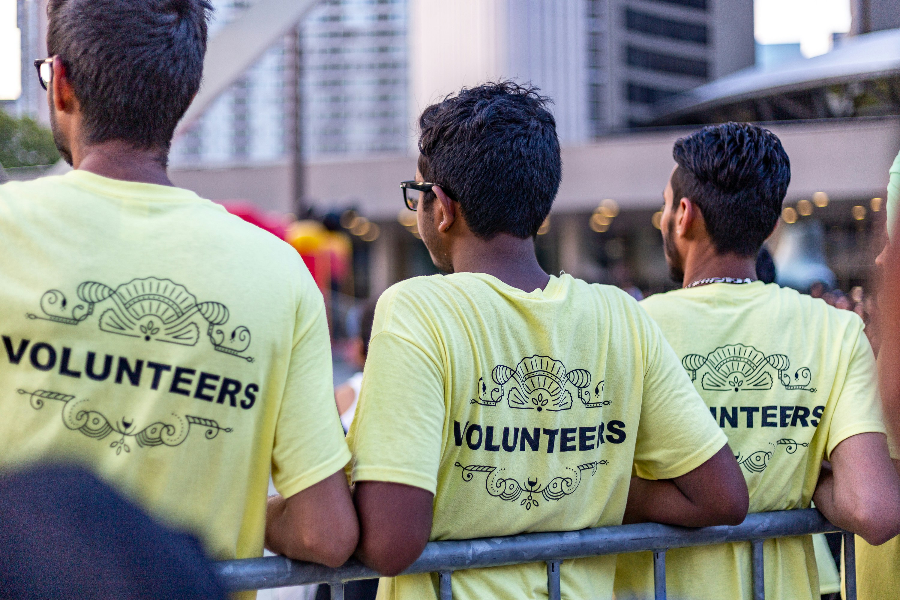 three men wearing yellow Volunteers shirts