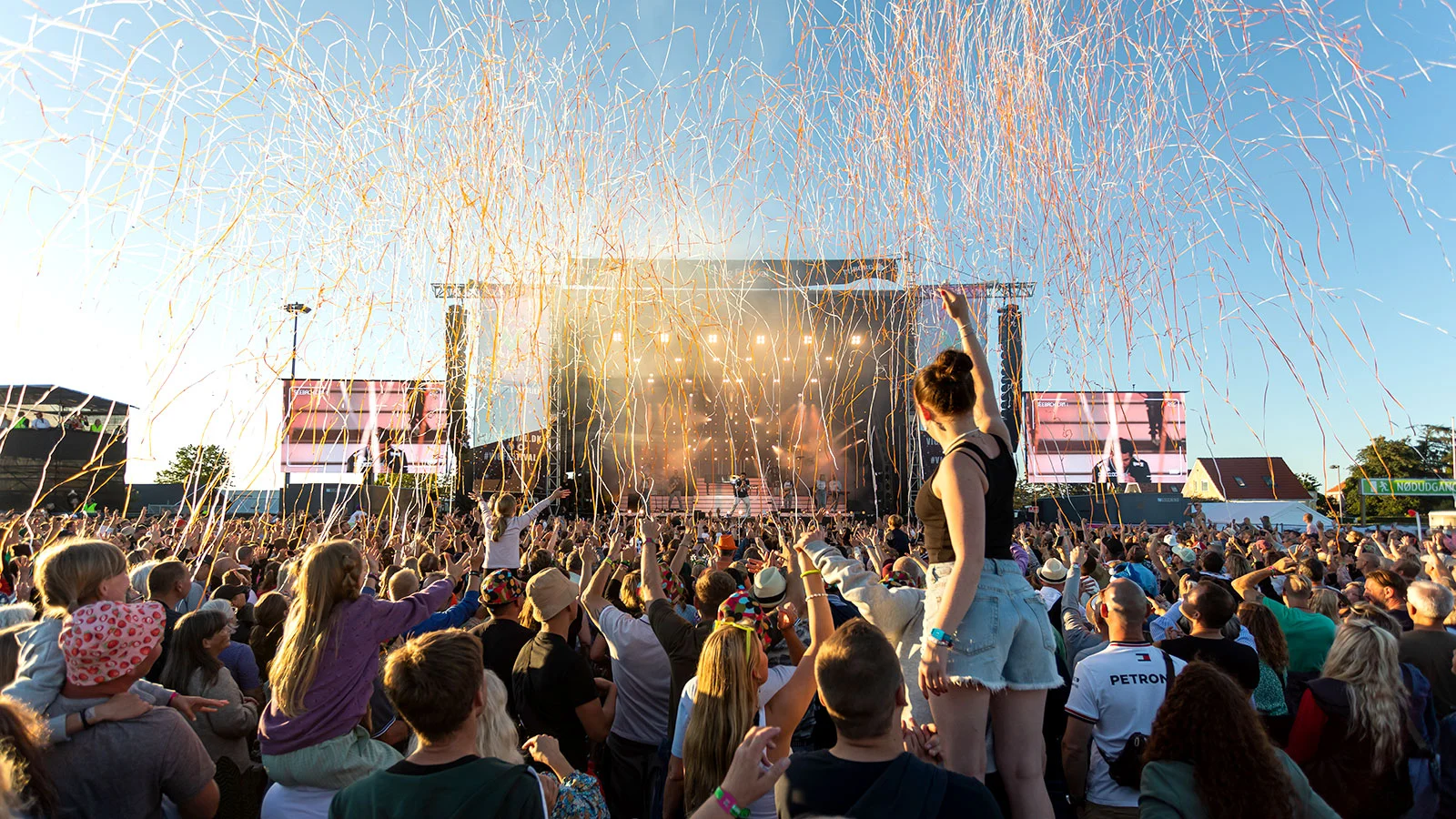 man singing while raising hands